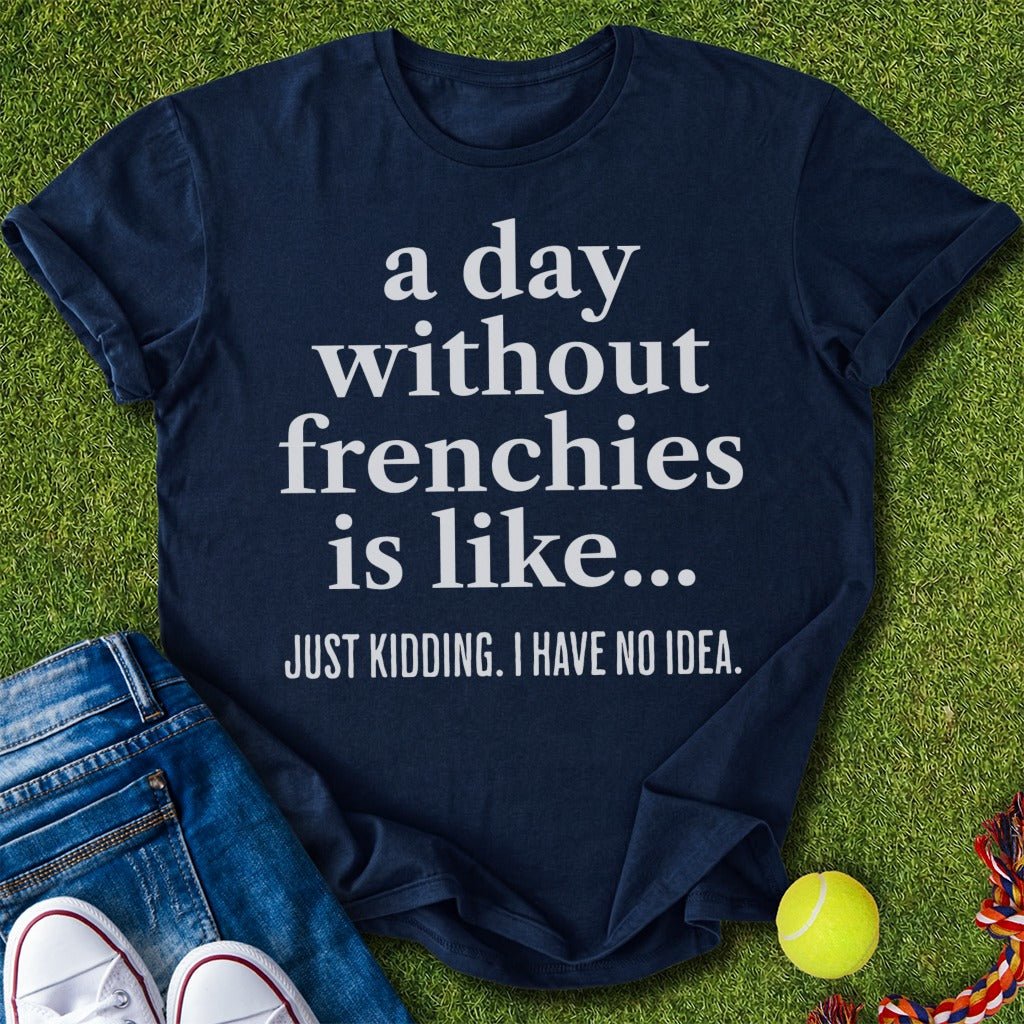 Navy blue t-shirt with humorous text on grass with jeans and tennis ball